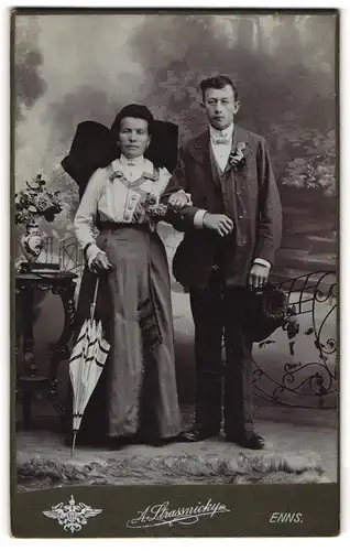 Fotografie A. Strassnicky, Enns, Mutter und Sohn in festlicher Tracht mit Blumengestecken