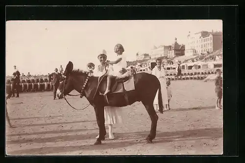 AK Kleines Mädchen auf einem Esel am Strand