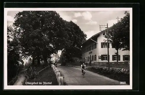 AK Obergries im Isartal, Mann auf Fahrrad passiert den Ort