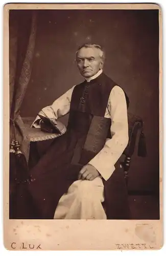 Fotografie C. Lux, Zwettl, Portrait älterer Pfarrer im lithurgischen Gewand mit Bibel in der Hand