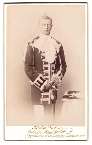 Fotografie Atelier Victoria, Berlin, Portrait junger Mann als höfischer Kammerdiener in Uniform mit Säbel