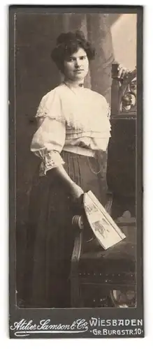 Fotografie Atelier Samson & Co, Wiesbaden, Gr. Burgstr. 10, junge Frau mit weisser Bluse hält Magazin in der Hand