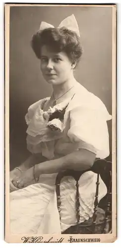 Fotografie W. Kleinschmidt, Braunschweig, Frau mit angesteckter Rose am Kragen und weisse Schleife im Haar