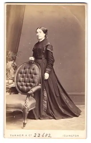 Fotografie Turner & Co., Islington, Dame mittleren Alters im schwarzen Biedermeierkleid mit Brosche am Kragen