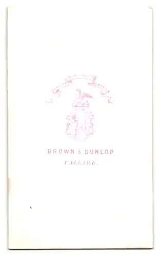 Fotografie Brown & Dunlop, Falkirk, Kleinkind im weissen Kleidchen auf einem Stuhl sitzend