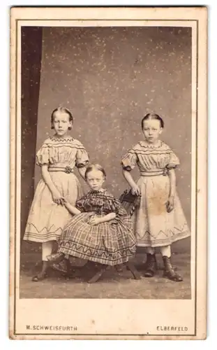 Fotografie M. Schweisfurth, Elberfeld, Königstrasse 10, Drei Schwestern in hochwertigen Kleidern