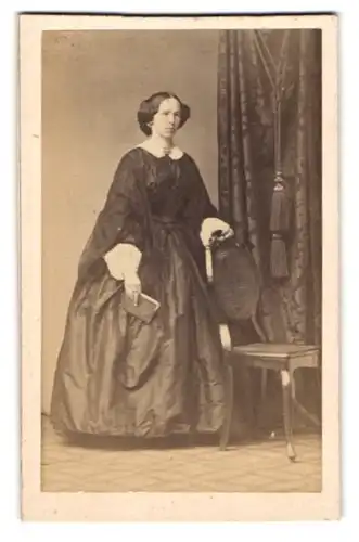 Fotografie unbekannter Fotograf und Ort, Junge Frau mit kurzen, hoch gesteckten Haaren im schwarz-weissen Kleid