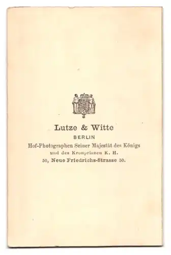 Fotografie Litze & Witte, Berlin, Neue Friedrichsstrasse 50, Junger Herr mit Vollbart neben einem Sektretär posierend