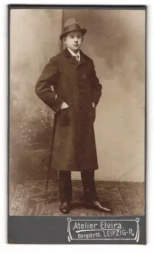 Fotografie Atlier Elvira, Leipzig, Portrait junger Mann im Mantel mit Hut und Stock