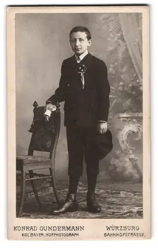 Fotografie Konrad Gundermann, Würzburg, junger Knabe im dunklen Anzug mit Hut zu seiner Kommunion