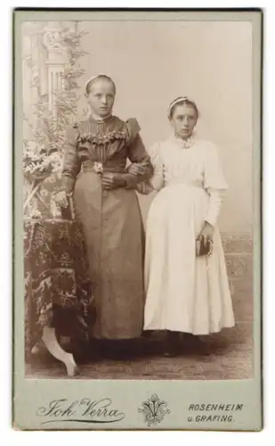 Fotografie Joh. Verra, Rosenheim, Portrait zwei Schwestern in Kommunionskleidern posieren im Atelier