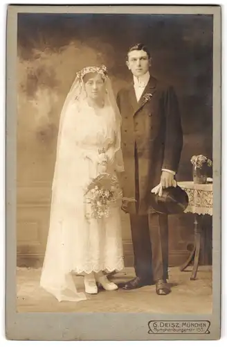 Fotografie G. Deisz, München, Portrait junges Brautpaar am Hochzeitstag im Kleid und Anzug mit Zylinder