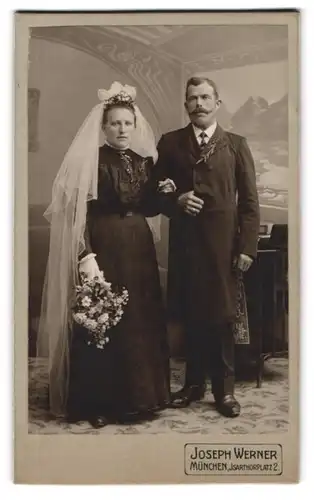 Fotografie Joseph Werner, München, Portrait Eheleute im schwarzen Brautkleid und Anzug mit Brautstrauss