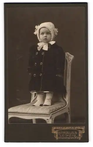 Fotografie Strauss, Leipzig, Windmühlenstr. 8-12, Mädchen mit Mantel & Mütze auf Stuhl stehend