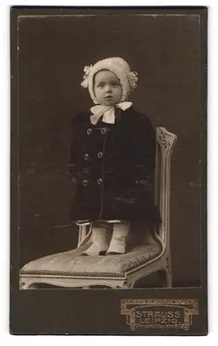 Fotografie Strauss, Leipzig, Windmühlenstr. 8-12, Mädchen mit Mütze & Mantel auf Stuhl stehend