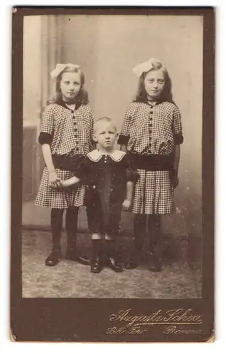 Fotografie Augusta Schou, Rönne, Knabe von Mädchen im gleichen Kleid flankiert
