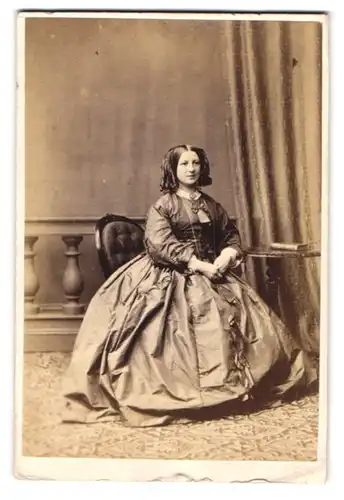 Fotografie John Burton & Sons, Birmingham, Junge Dame mit Korkenzieherlocken in einem hochwertigen Biedermeierkleid
