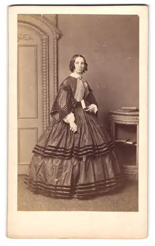 Fotografie F. C. Earl, Worcester, 46. Broad Street, Junge Dame mit Korkenzieherlocken im eleganten Reifrockkleid