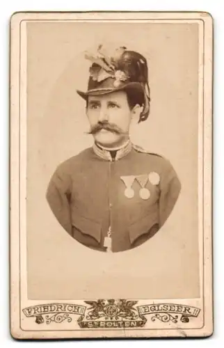 Fotografie Friedrich Eglseer, St. Pölten, Portrait K.u.K. Soldat in Uniform mit Orden an der Brust und Federhut