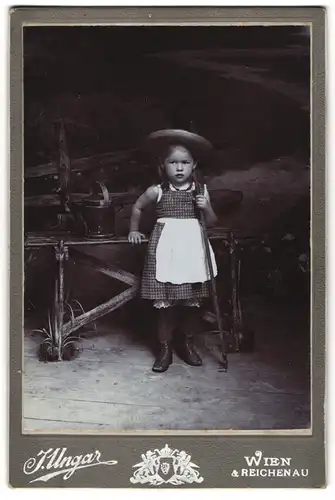 Fotografie J. Ungar, Wien, Portrait kleines Mädchen im karierten Kleid mit Rechen und Gieskanne