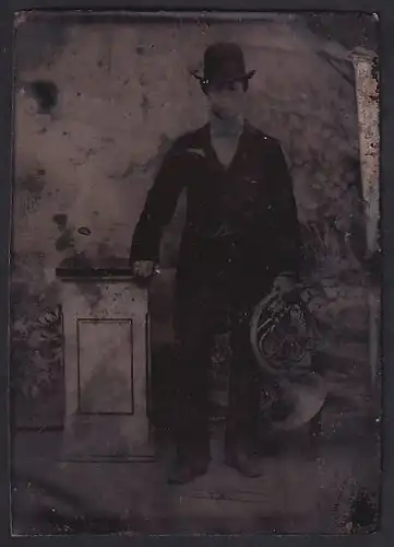 Fotografie Ferrotypie junger Mann im Anzug mit Melone und Blashorn in der Hand