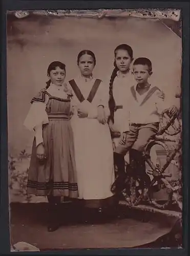 Fotografie Ferrotypie vier Kinder in Kleidern und Mädchen mit langem geflochtenem Zopf
