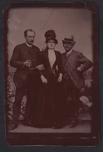 Fotografie Ferrotypie zwei Herren und eine Dame im Biedermeierkleid posieren im Atelier