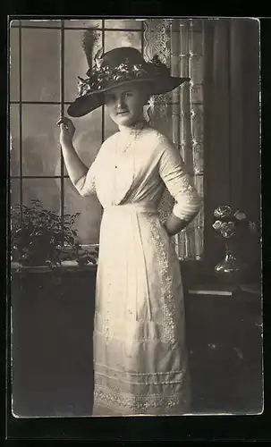 AK Frau stehend am Fenster im weissen Kleid mit Hut