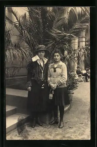 AK Damen an der Palme, portraitiert mit Hut