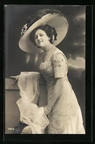 AK Frau im weissen Kleid an einer Mauer mit einem ausladenden Hut