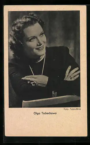 AK Schauspielerin Olga Tschechowa, auf einem Stuhl sitzend, die Arme verschränkt