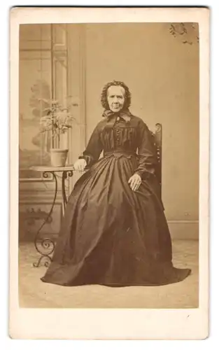 Fotografie B. Telly, Lincoln, Freundliche ältere Frau mit Kopfbedeckung in tailliertem Kleid