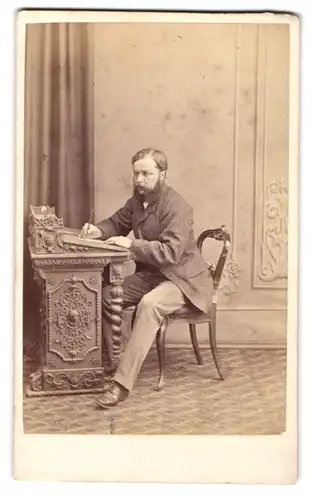 Fotografie B. J. Edwards, Wrexham, Hope Street, Vollbärtiger Mann mittleren Alters an seinem Sekretär schreibend