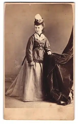 Fotografie W. Rowe, Leicester, 82. High Street, Junge Dame mit Federhut und edlem Mantel über ihrem Biedermeierkleid