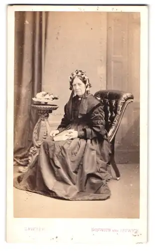 Fotografie Sawyer, Norwich, 46. London Street, Gestandene Frau mit Blumengesteck im Haar im imposanten Kleid