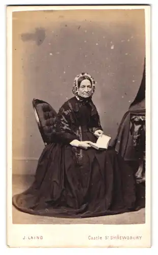 Fotografie J. Laing, Shrewsburry, Castle Street, Greisin mit Haube im schwarzen Kleid ein Buch lesend