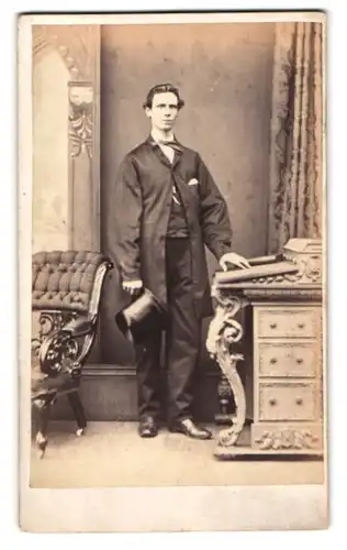 Fotografie Turnbull & Son, Glasgow, 75. Jamaica Street, Gross gewachsener, junger Herr im Anzug mit Zylinder in der Hand