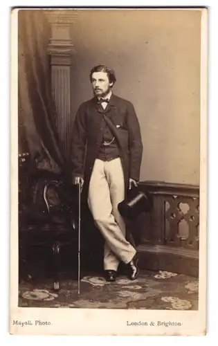 Fotografie Mayall, London, 224. Regent Street, Junger Mann mit dünnem Vollbart im Anzug mit Zylinder und Gehstock