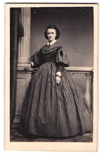 Fotografie E. Luban, Görlitz, Dame mit grimmigem Blick in einem gestreiften Biedermeierkleid mit Verzierungen