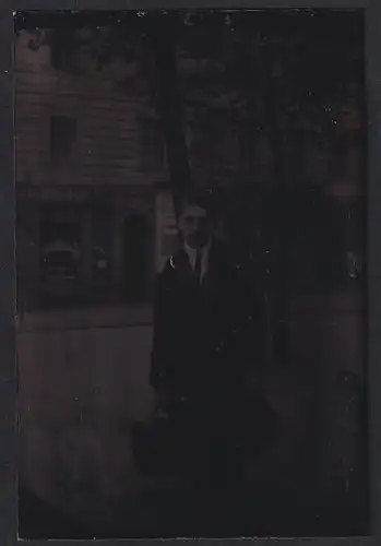 Fotografie Ferrotypie junger Mann im Anzug mit Tasche und Hut vor einer Schultheis Kneipe, Litfasssäule