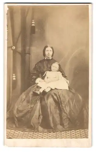 Fotografie H. J. Hughes, Carnarvon, Junge Mutter im weiten Biedermeierkleid mit dem Säugling im Schoss