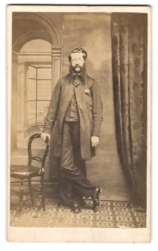 Fotografie H. J. Hughes, Carnarvon, Bärtiger Herr mit teuren Anzug in lässiger Pose an einen Stuhl gelehnt