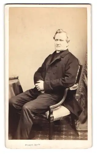 Fotografie J. Stuart, Inverness, Finster drein blinkender Mann mit modischer Anzugjacke in einem Stuhl sitzend