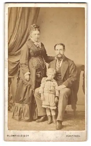 Fotografie Blomfield & Co., Hastings, Junges Paar mit dem gemeinsamen Nachwuchs fein herausgeputzt