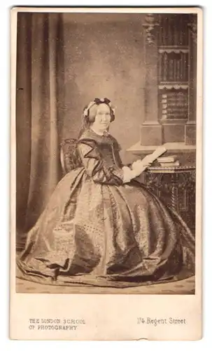 Fotografie Mr. S. Prout Newcombe, London, 174 Regent Street, Ältere Dame im Kleid mit einem Buch