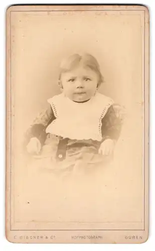 Fotografie E. Biegener & Co., Guben, Wilhelmsplatz 9, Baby mit weissem Latz