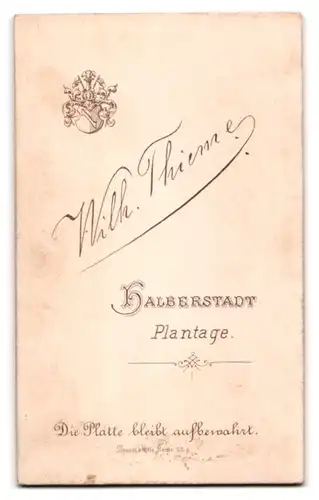 Fotografie Wilh. Thieme, Halberstadt, Plantage, Junge im Anzug mit Hand in der Tasche und Buch