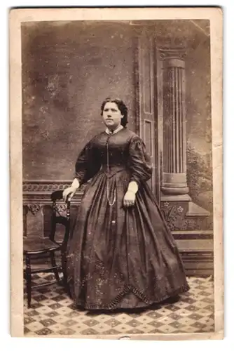 Fotografie J. T. Flatters, Bourne, Junge Dame im taillierten Reifrockkleid mit dicker Brosche am Kragen