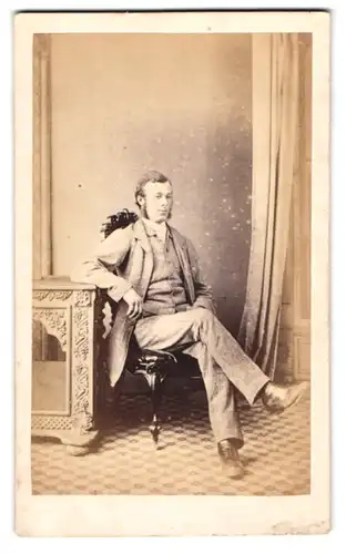 Fotografie E. Clark, Retford, Bärtiger Herr mit hellem Massanzug in lässiger Pose sitzend