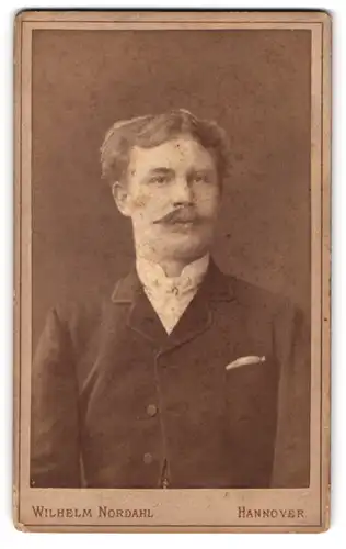 Fotografie Wilhelm Nordahl, Hannover, Humboldt-Strasse 1a, Junger Mann mit Oberlippenbart und Einstecktuch